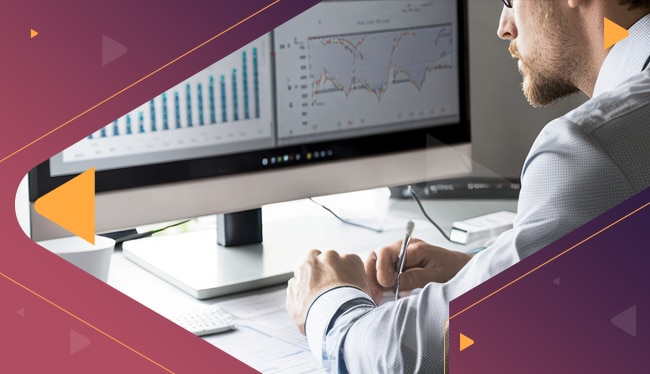 man on desk in front of his screen with dataviz